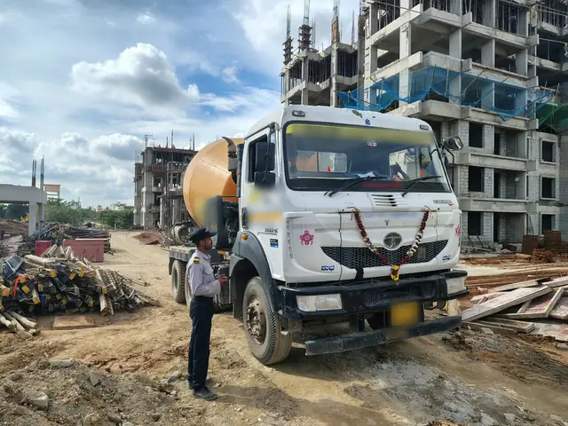 A security guard checking in a ready-mix truck at the gate of a construction site